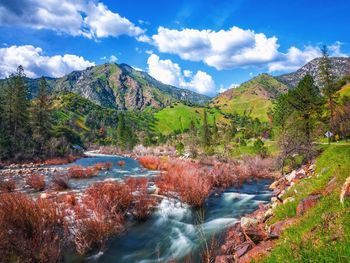 Scenic view of river amidst mountains against sky