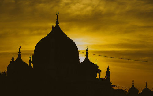 Low angle view of silhouette statue against sky during sunset