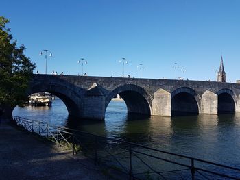 Bridge over river against clear blue sky