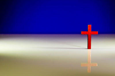 Close-up of cross against blue sky