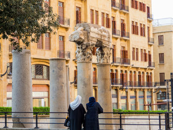 Rear view of man walking on building in city