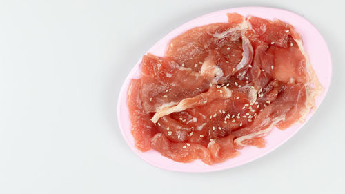 Close-up of strawberry in plate against white background