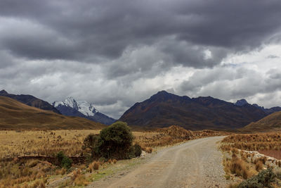 Road leading towards mountains against sky