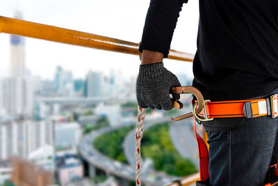 Construction worker wearing safety harness and safety line working at high place