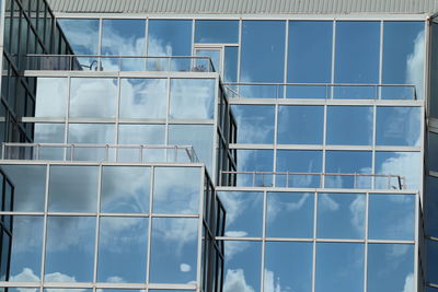 Low angle view of glass building against sky