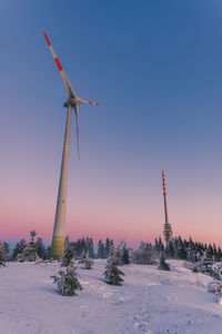 Windmill on field against clear sky during sunset