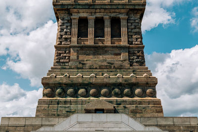 Low angle view of old building against cloudy sky