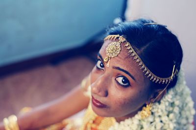 Close-up portrait of bride sitting at home