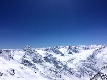 Scenic view of snowcapped mountains against clear blue sky