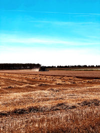 Scenic view of agricultural field against blue sky