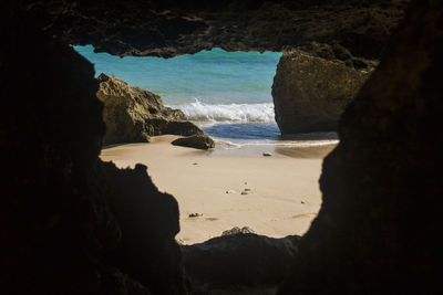 Rock formation on beach against sky