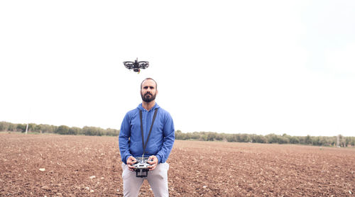 Young man prepares the battery of his drone in the field to go fly