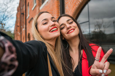 Portrait of smiling young woman holding camera