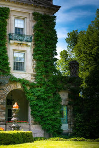 Statue by historic building against trees