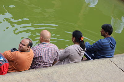 Rear view of people sitting in water