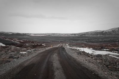 Road leading towards mountain against sky