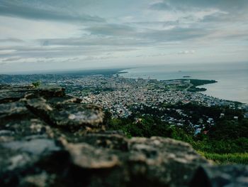 Aerial view of city by sea against sky