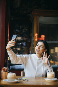 Young woman using smart phone in restaurant