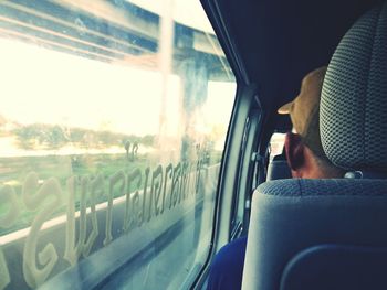 Low section of man sitting in train