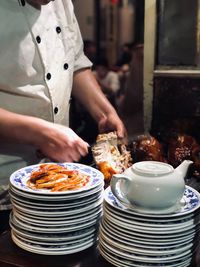 Midsection of man preparing food in restaurant