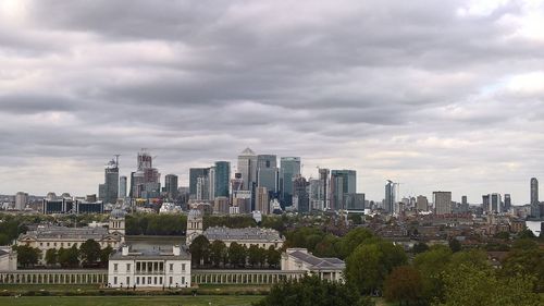 Buildings in city against cloudy sky