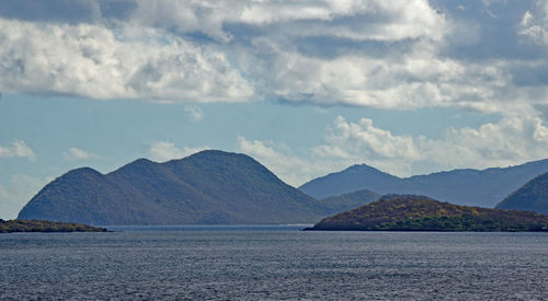 Scenic view of sea and mountains against sky