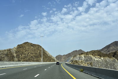 Road by mountain against sky