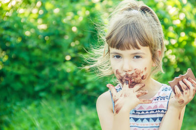 Portrait of young woman blowing dandelion