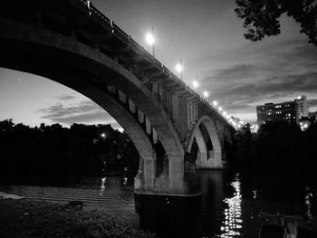 Bridge over river against sky at night