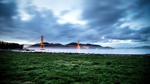 Scenic view of river against cloudy sky