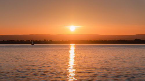 Scenic view of lake against romantic sky at sunset