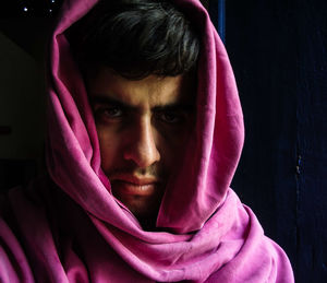 Portrait of serious man with pink scarf