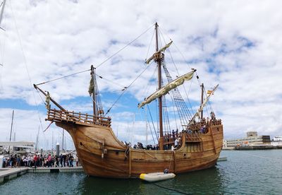 Sailboats moored in sea against sky