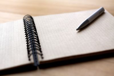 Close-up of pen on notepad at table