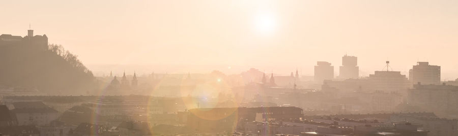 Buildings in city against sky during sunset