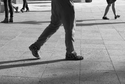 Low section of people walking on street