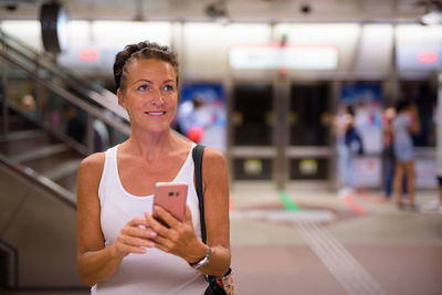 Portrait of woman using mobile phone in bus