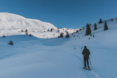 People skiing on snow covered landscape