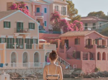 Rear view of woman standing against colorful buildings