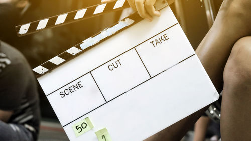 Cropped image of woman holding movie slate