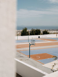 Basketball court with a scenic view of sea against sky