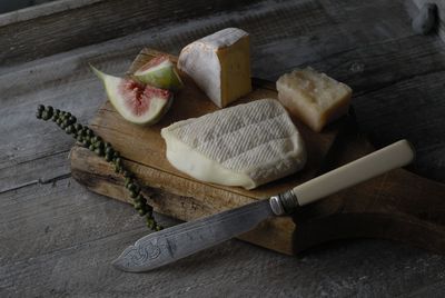 High angle view of cheese on cutting board over table