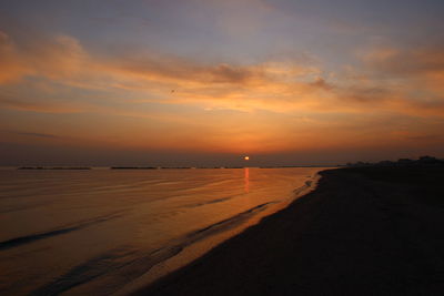 Scenic view of beach against sky during sunset