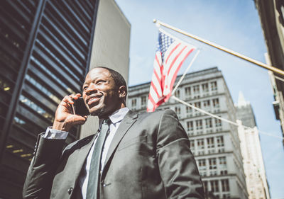 Low angle view of man flag against building in city