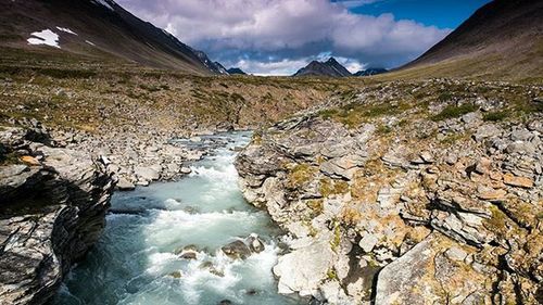 Scenic view of mountains against cloudy sky