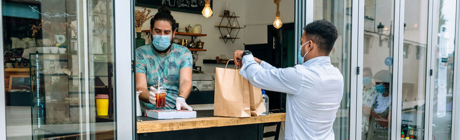 Owner selling coffee to customer