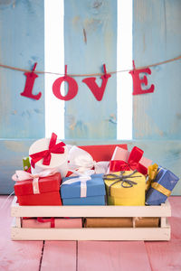 Gifts on sofa with love text hanging on wall