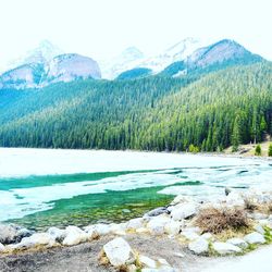 Scenic view of lake by mountains against sky