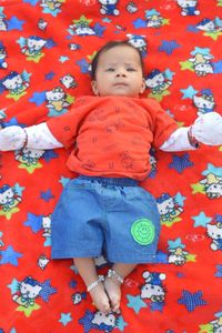 High angle view of baby lying on bed