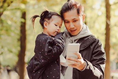 Portrait of happy man holding mobile phone